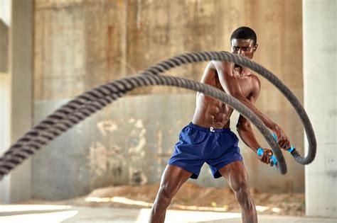 Premium Photo | Rope workout sport man doing battle ropes exercise ...