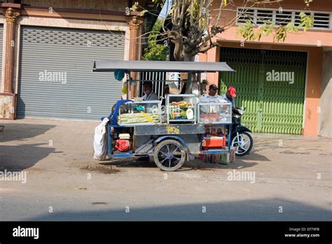 A mobile food cart is parked on a city street in Kampong Cham, Cambodia ...