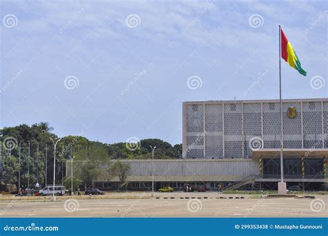 Guinea Conakry Flag Waving Outside on Blue Sky Building Background ...