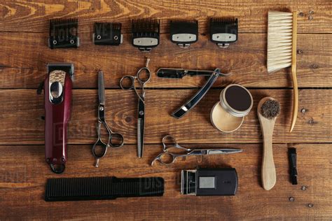 Top view of various professional barber tools on wooden surface in hair ...