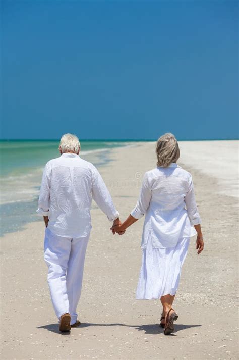 Happy Senior Couple Holding Hands on a Beach Stock Image - Image of ...