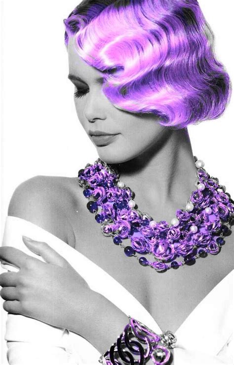 a black and white photo of a woman with pink hair wearing a purple statement necklace