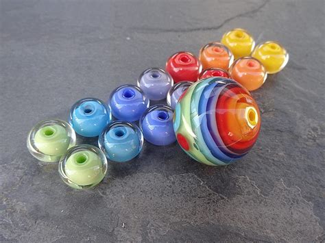 a group of colorful glass beads sitting on top of a cement floor next to each other