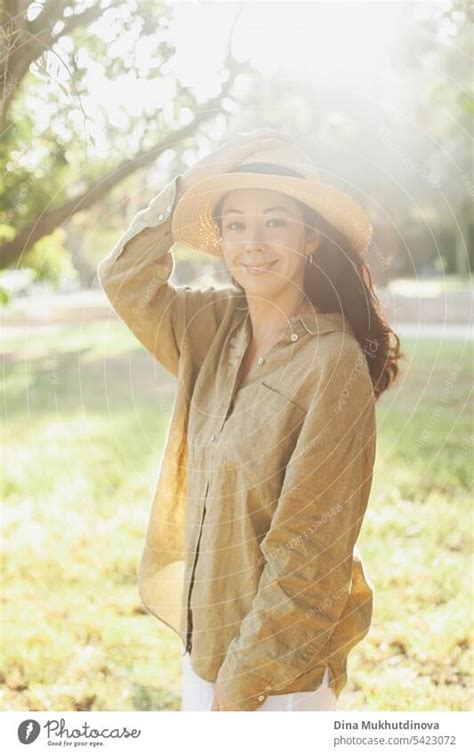 beautiful 30 year old millennial woman in hat and olive green linen ...