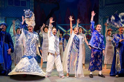 a group of people standing on top of a stage with their hands in the air