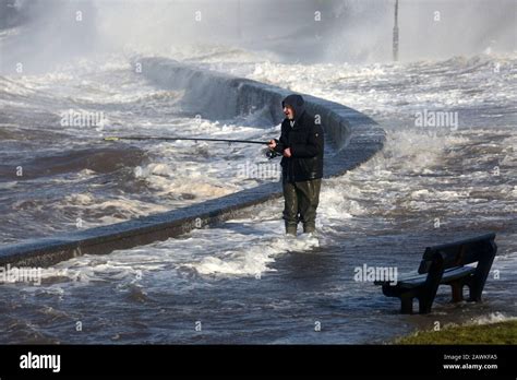 Scotland, Ayrshire, Prestwick, Storm Ciara 02 Feb 2020 A lone fsherman angler battles waves ...