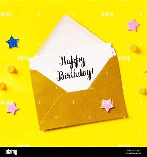 Happy Birthday card in a golden envelope, overhead square shot on a ...