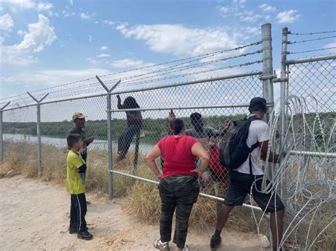 WATCH: Migrant families scale barbed wire fence into South Texas