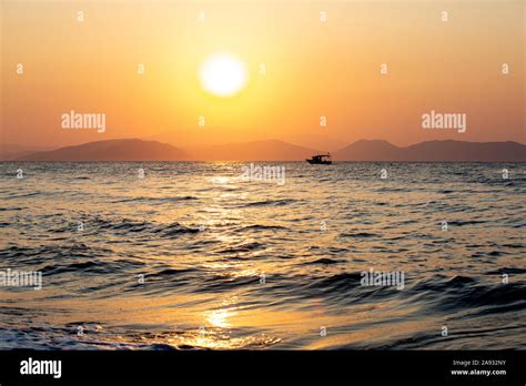 silhouette of fishing boat on front of sunset Stock Photo - Alamy