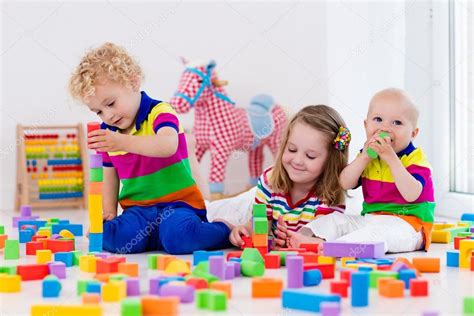 Kids playing with colorful toy blocks Stock Photo by ©FamVeldman 117913846