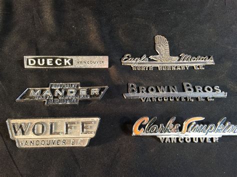 COLLECTION OF 6 VINTAGE METAL CAR BRAND/DEALERSHIP DECALS