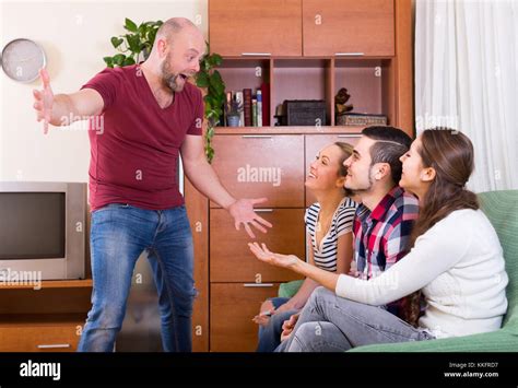 Happy adults showing charades indoor and laughing Stock Photo - Alamy