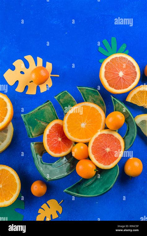 Exotic fruits close-up. Mango, oranges, kumquat and other tropical fruits vibrant blue ...
