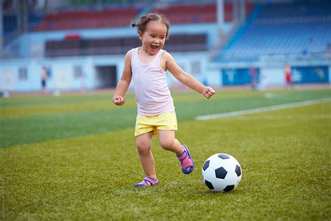 "Little Girl Playing Football Outdoor In The Football Field" by Stocksy Contributor "Bo Bo ...