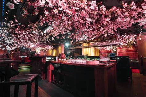 a bar with pink flowers on the ceiling