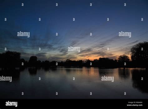 View across the fishing lake at sunset in Bushy Park, Richmond, UK ...