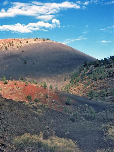 Clouds above the red and black slopes of Sunset Crater - along the Lava ...