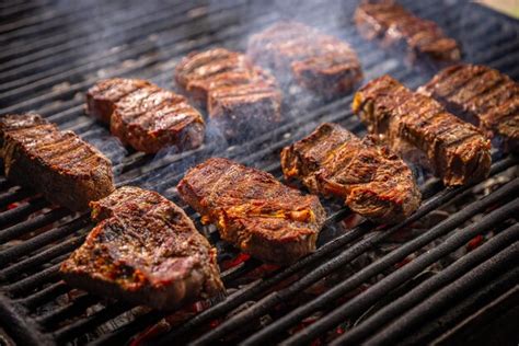 Premium Photo | Several pieces of steak sizzling on a grill