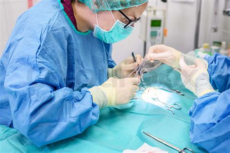 Female surgeon in operation room, operating a patient. | Stock image | Colourbox