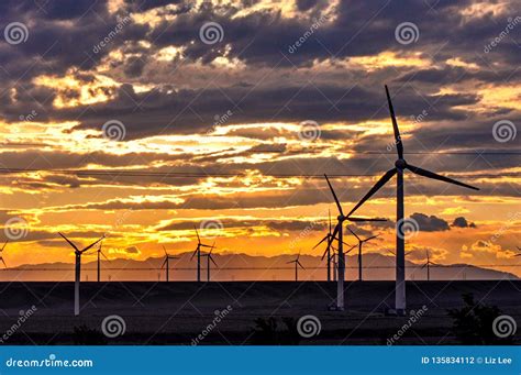 Wind turbine at sunset stock photo. Image of horizon - 135834112