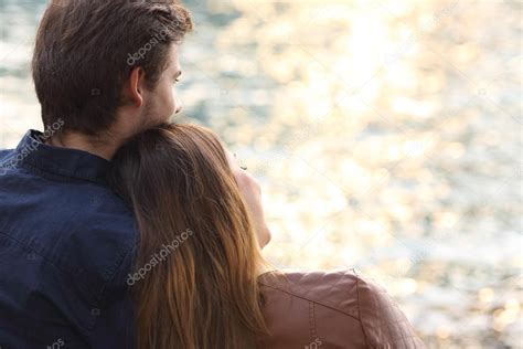 Couple hugging and watching sunset on the beach Stock Photo by ©AntonioGuillemF 64827221