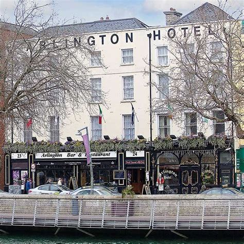 there is a bridge that goes over the water in front of a building with lots of windows