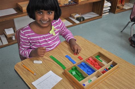 Primary student using Montessori materials in the classroom ...