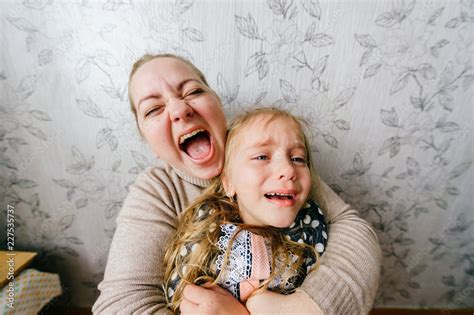 Young mother with child beautiful girl crying and laughing together ...