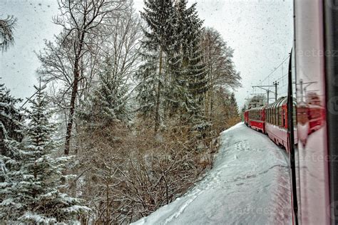 Red train in the snow in swiss alps 11947817 Stock Photo at Vecteezy