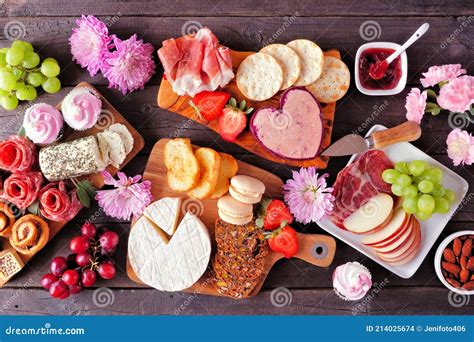 Mothers Day Charcuterie Table with a Dark Wood Background. Assorted Cheese, Meat, Fruit and ...