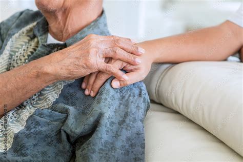 Old man holding hands of his son at home Stock Photo | Adobe Stock