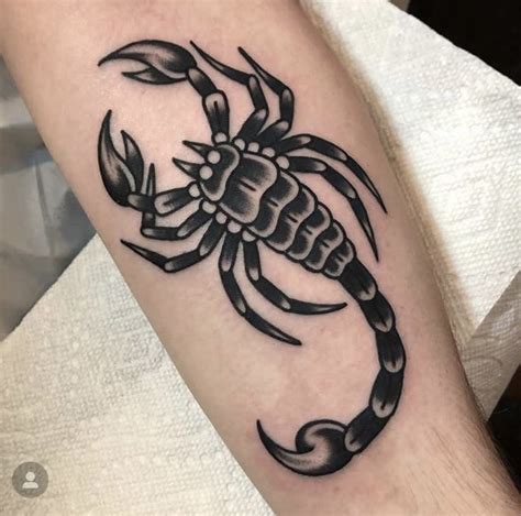 a black scorpion tattoo on the arm