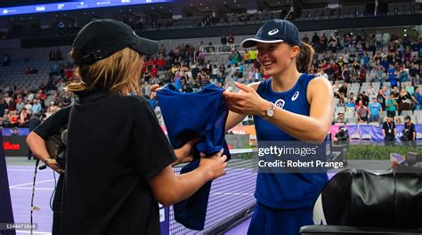 Iga Swiatek of Poland gifts one of her match outfits to a ballgirl ...