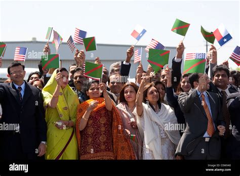 Ismaili Muslims wave small Ismaili and Texas flags while greeting the Aga Khan during a ceremony ...