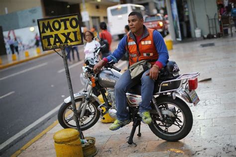 A motorcycle taxi driver waits for customers in downtown Caracas