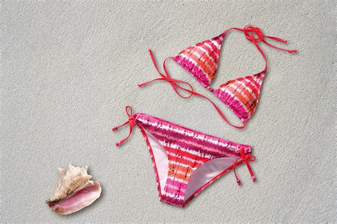 Royalty-Free photo: Women's pink and orange striped bikini on sand ...