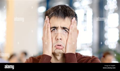 Guy clamps face with hands making a funny sad face Stock Photo - Alamy