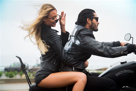 a man riding on the back of a motorcycle next to a woman