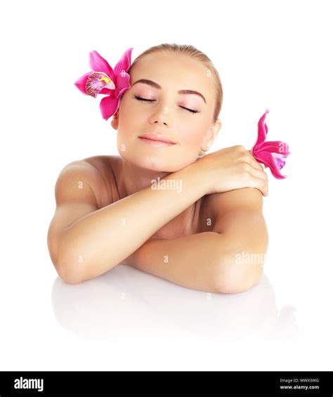 Beautiful sleeping woman in spa salon, pretty female face with pink orchid flower, cute girl ...