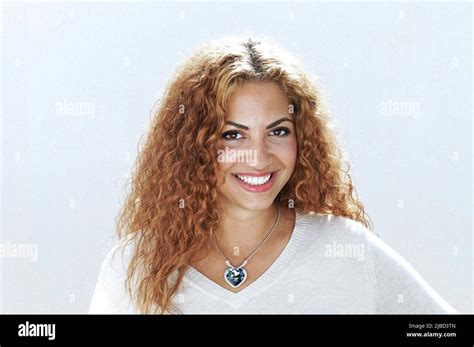 Young, smiling lady, with reddish tinted curly hair and blue crystal ...