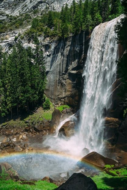 Premium Photo | A rainbow appears over a waterfall.