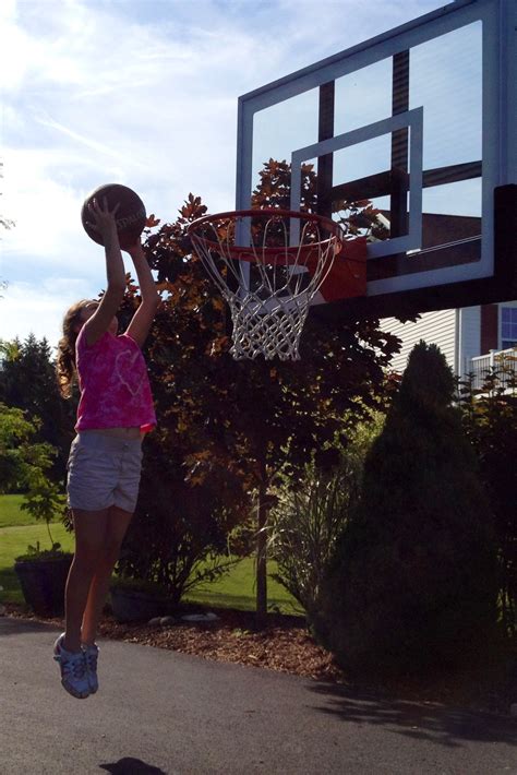 Young girl has fun dunking on the Pro Dunk Bronze basketball system ...