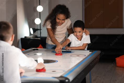 Little children playing air hockey indoors Stock Photo | Adobe Stock