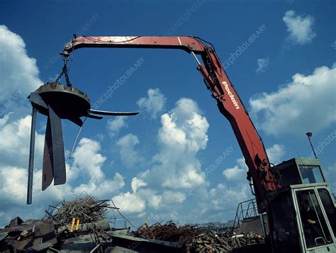 Large electromagnet in use at a scrapyard - Stock Image - T820/0086 - Science Photo Library