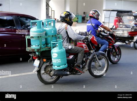 Antipolo City, Philippines - June 1, 2020: RIder use motorcycle to deliver multiple tanks of LPG ...