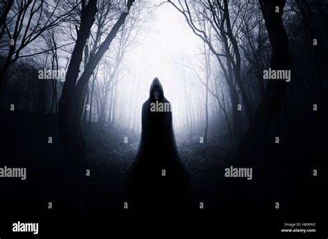 scary cloaked figure in dark scary forest Halloween landscape Stock Photo - Alamy