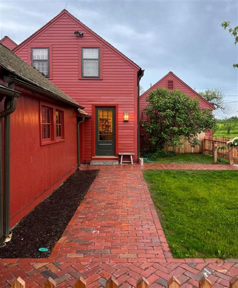 A reclaimed brick walkway leads to a beautiful red colonial home ...