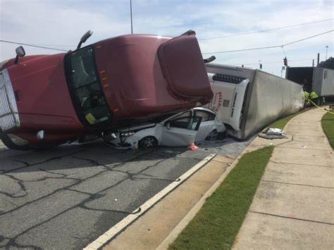 Tractor-trailer crash leaves car nearly crushed in Gwinnett