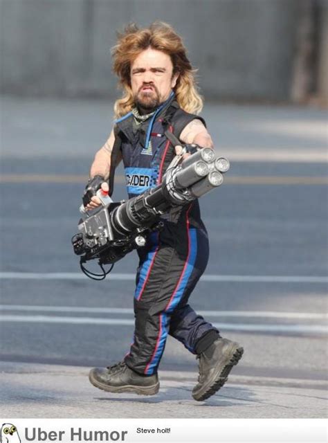 Peter Dinklage with a mullet, wearing a sleeveless jumpsuit, and ...