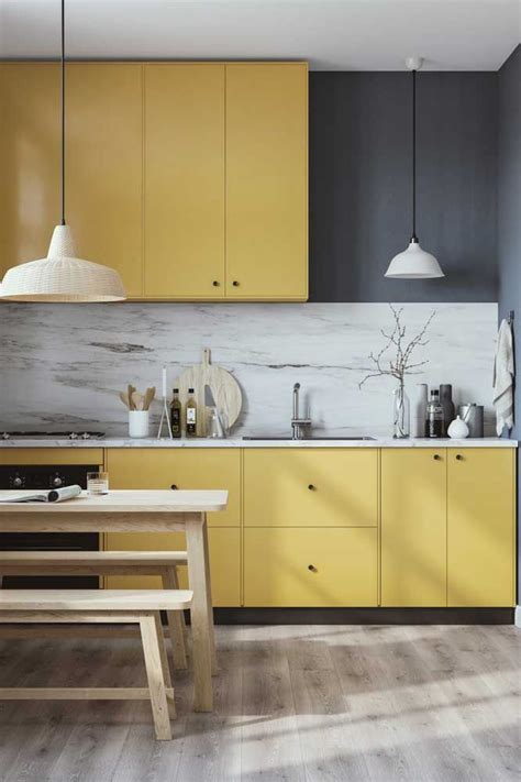 a kitchen with yellow cabinets and wooden floors
